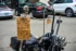 Color photo. A skeleton sits on a motorcycle, holding a sign. The sign reads: My "best friend" said no more free rides. So here I sit! Get a haircut from him so we have gas money!!! His Instagram is @garretts_haircuts. Tell him G-Bone sent you.